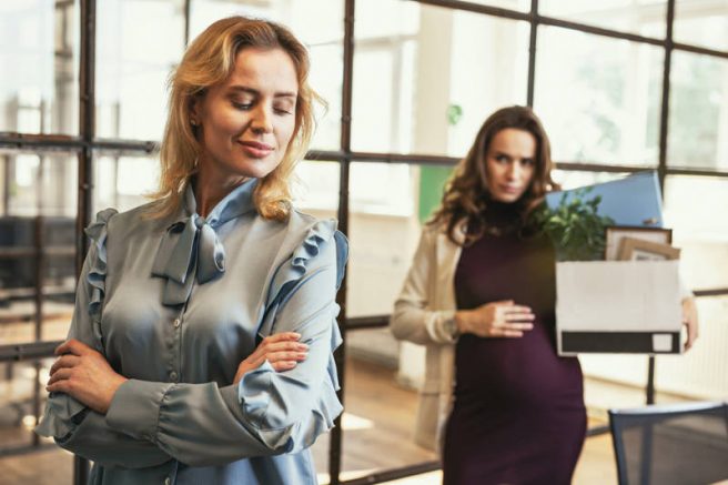 femeie insarcinata la munca, gravida la munca, femeie gravida la birou cu laptop in mana