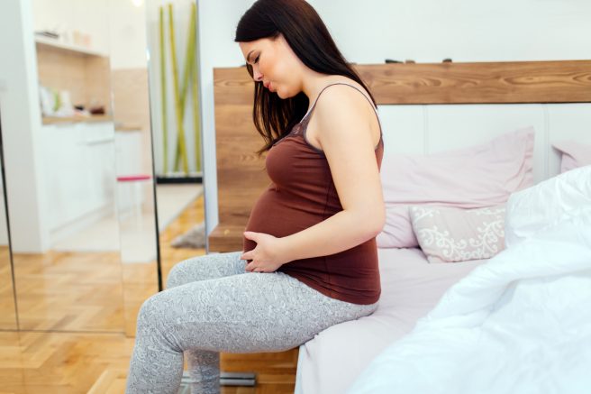 Pregnant woman having belly ache and cramps , spasms