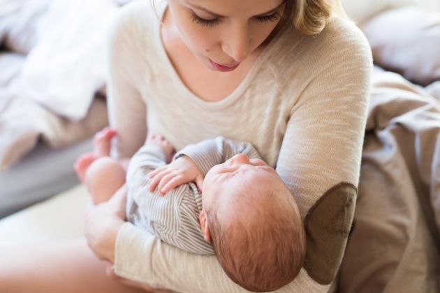 bebe doarme leganat in bratele mamei