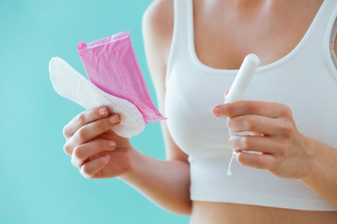 prim-plan-cu-o-femeie-care-tine-in mana-produse-pentru-menstruatie precum-tampoane-interne-si-absorbante-pentru-menstruatia-dupa-nastere