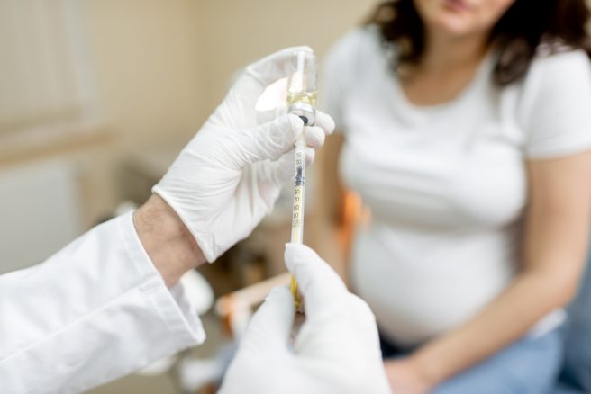 medic-extrage-vaccin-antitetanos-dintr-un-flacon-pentru-o-femeie-gravida