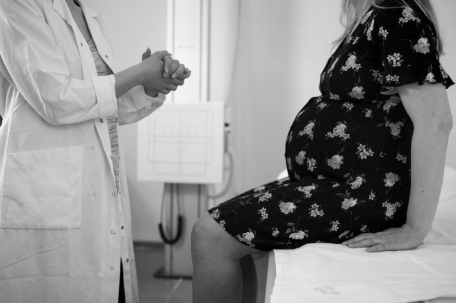 Femeie însărcinată care discută cu medicul obstretician