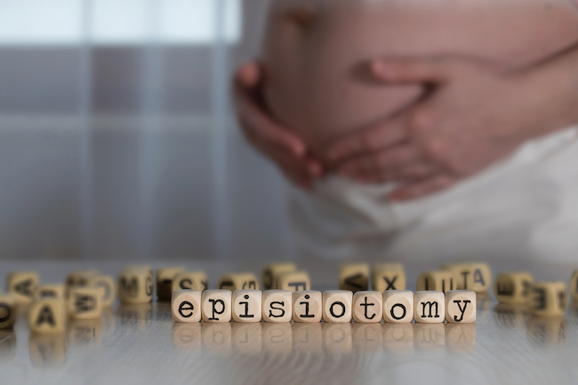 femeie-gravida-care-se-ține-de-burta-si-cuburi-pe-care-scrie-epiziotomie