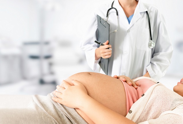 femeie-gravidă-cu-triplu-test-care-stă-pe-spate-si-un-doctor-lângă-ea
