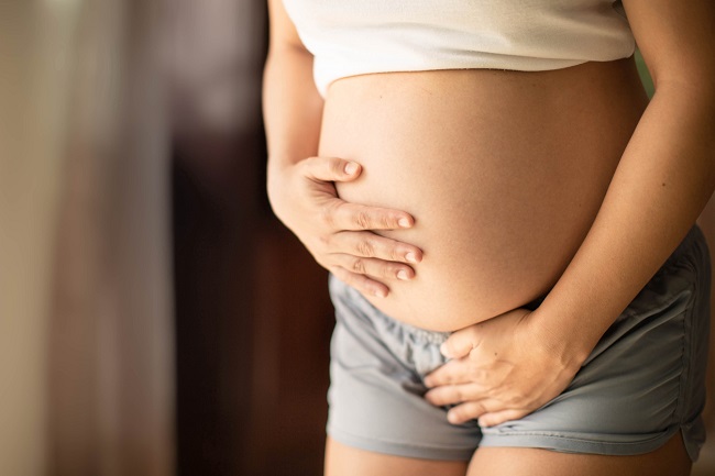 femeie-gravidă-cu-burta-goală-care-se-ține-de-burtă-și-are-incontinență-urinară-în-sarcină