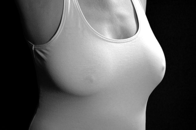 Sâni de femeie sub bluză albă