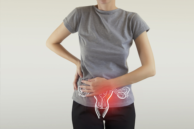 femeie-care-se-ține-de-o-parte-a-abdomenului-și-o-ilustrație-cu-trompe-uterine