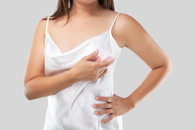 femeie-în-bluză-din-satin-ăși-autoexminează-unul-dintre-sâni-pentru-noduli-la-sân-dureroși