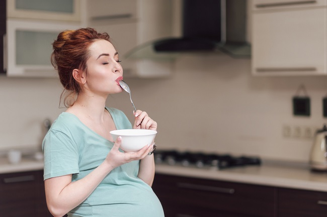 femeie-gravidă-care-mănâncă-cu-poftă-dintr-un-bol-alb-ca-metodă-de-prevenție-pentru-anemia-în-sarcină